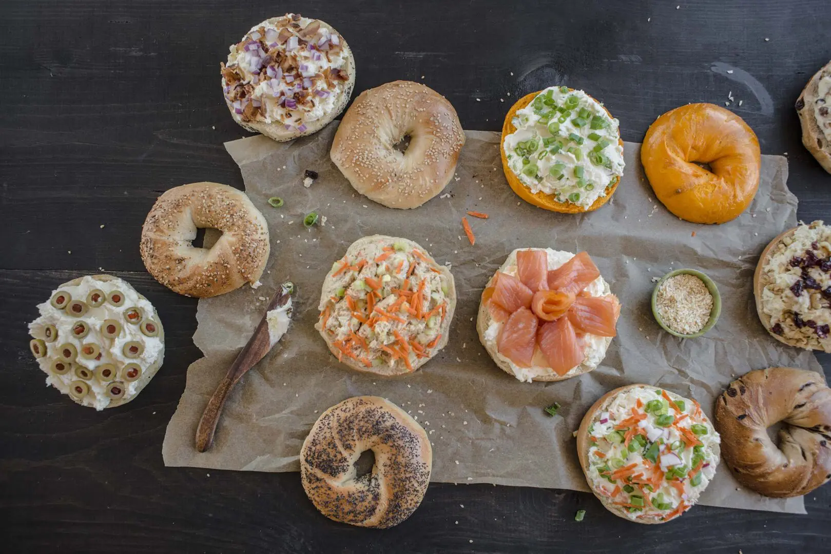 A table topped with lots of different bagels.