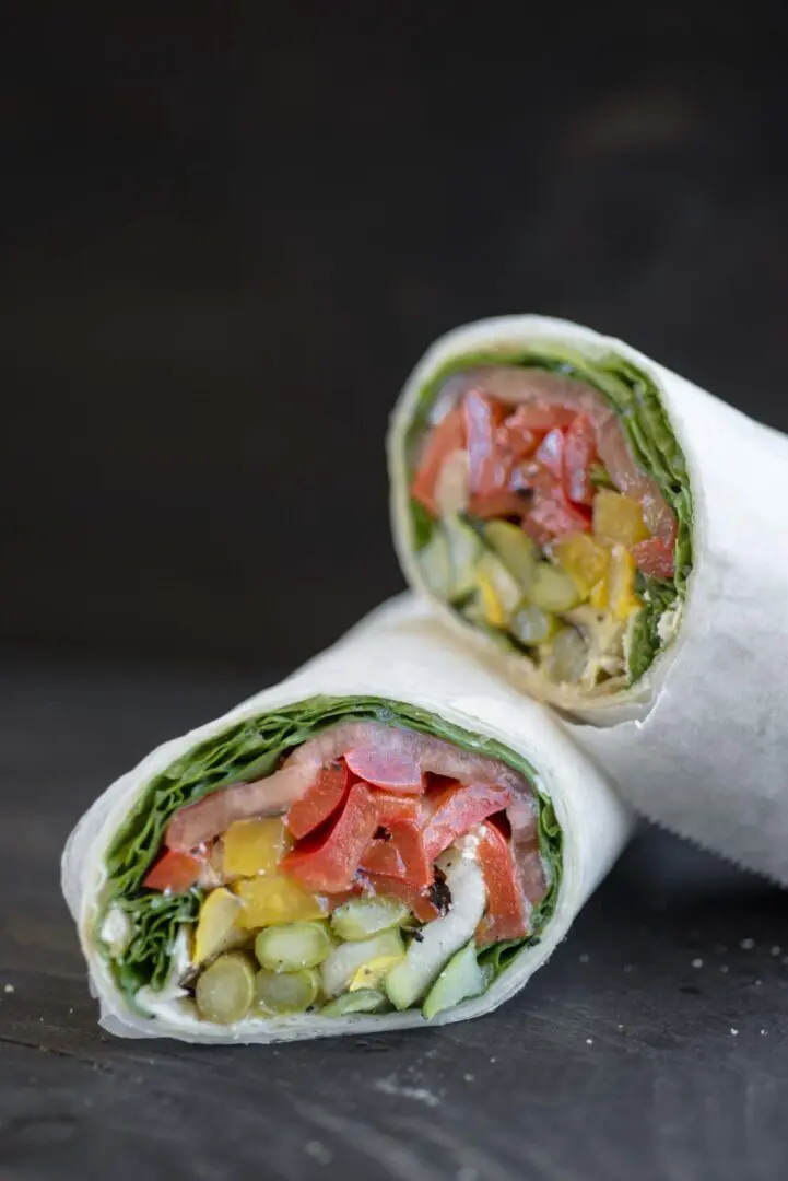 A close up of two wraps with different types of food