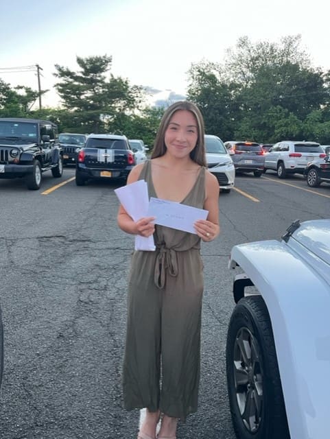 A woman standing in front of some cars