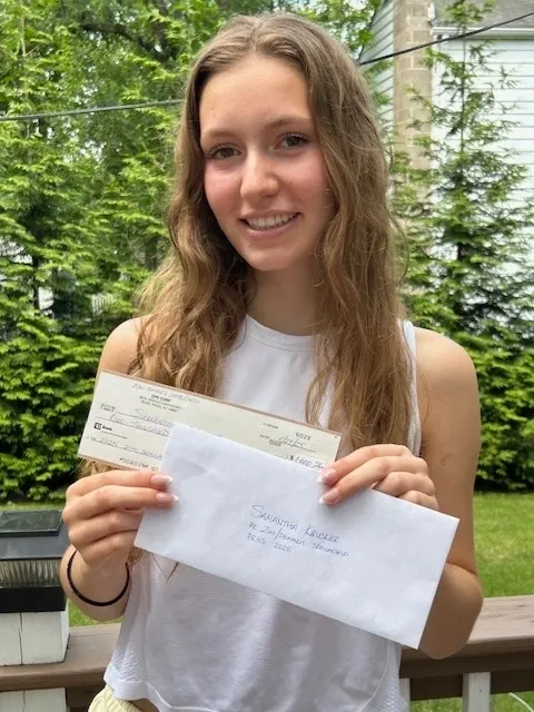 Sam.Krucker PR Zimi Scholarship 2025 Young woman holding papers.